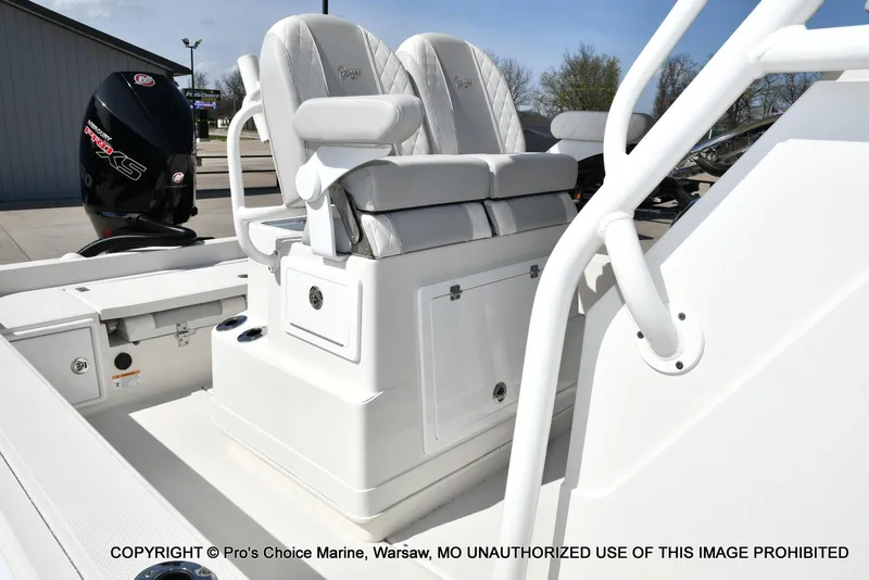 Slide: The Image of 2023 Ranger 2360 Bay boat interior with seating and motor, displayed at a marina. - 7