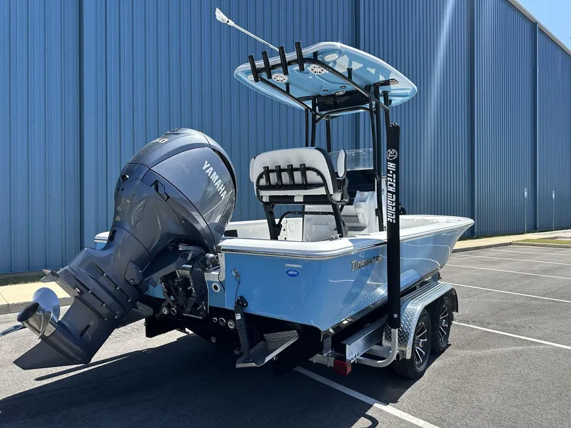Slide: The Image of 2025 Tidewater 2110 Bay Max boat with Yamaha engine on trailer, parked by blue building. - 12