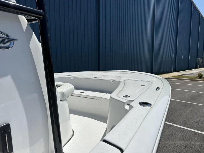 Slide: The Image of 2025 Tidewater 2110 Bay Max boat docked near a blue warehouse. - 16