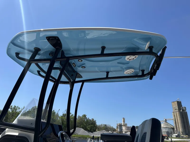 Slide: The Image of 2025 Tidewater 2110 Bay Max boat with blue T-top and speakers under clear sky. - 8