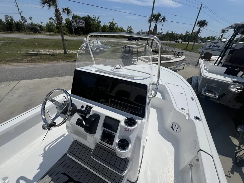 Slide: The Image of 2025 Tidewater 2110 Bay Max boat interior with steering wheel and console, docked outdoors. - 11