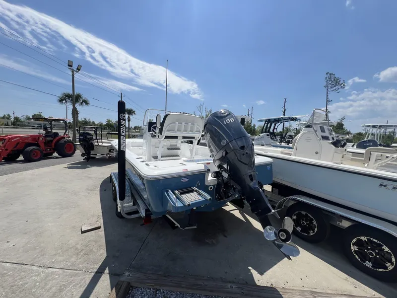 Slide: The Image of 2025 Tidewater 2110 Bay Max boat with outboard motor, parked outdoors under a clear sky. - 3