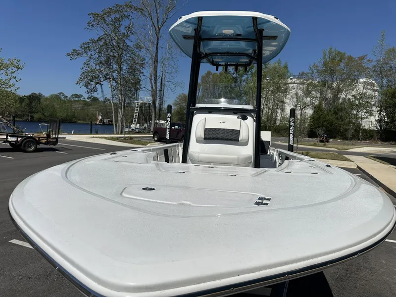 Slide: The Image of 2025 Tidewater 2110 Bay Max boat, parked near a lake, showcasing sleek design and spacious deck. - 7