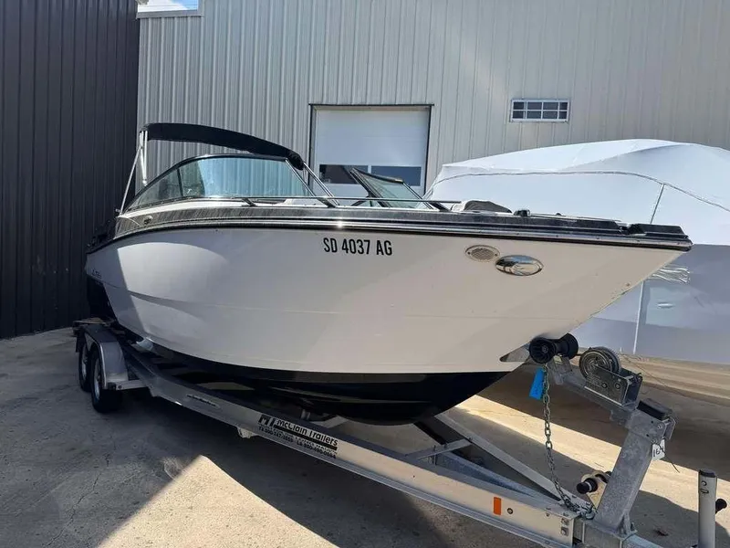 Slide: The Image of 2015 Monterey 258SS boat on trailer, parked outside a building. - 1