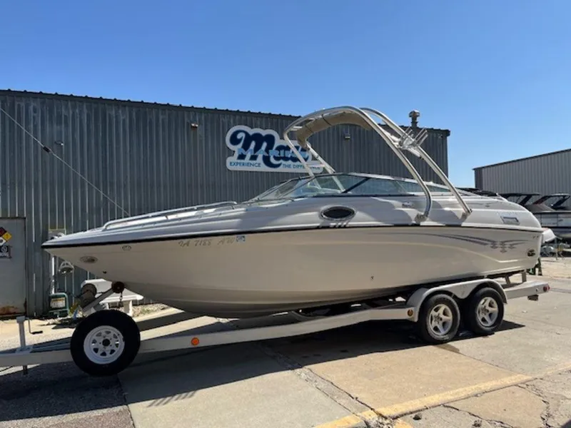 Slide: The Image of 2004 Crownline 230BR boat on trailer outside a metal building. - 1