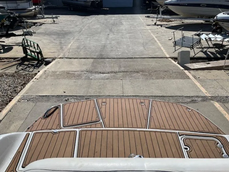 Slide: The Image of 2004 Crownline 230BR boat on trailer, wooden deck, parked in marina. - 5