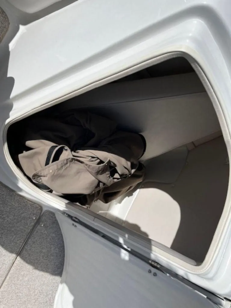 Slide: The Image of Storage compartment in a 2004 Crownline 230BR boat with folded fabric inside. - 8