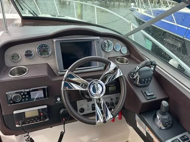 Slide: The Image of Cockpit of 2015 Regal 32 Express boat with steering wheel and navigation controls. - 13