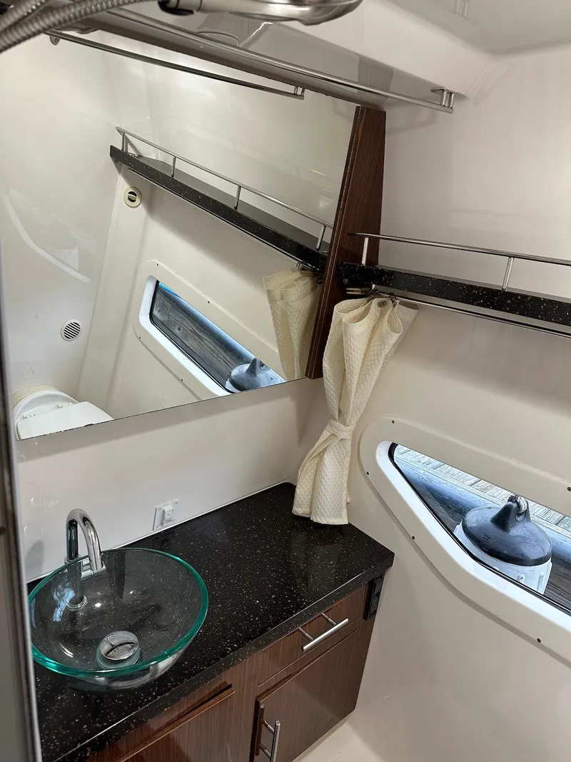 Slide: The Image of 2015 Regal 32 Express bathroom with modern sink, mirror, and window. - 21