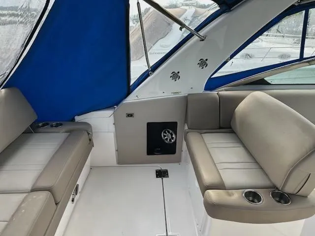 Slide: The Image of 2015 Regal 32 Express boat interior with beige seating and blue canopy. - 8