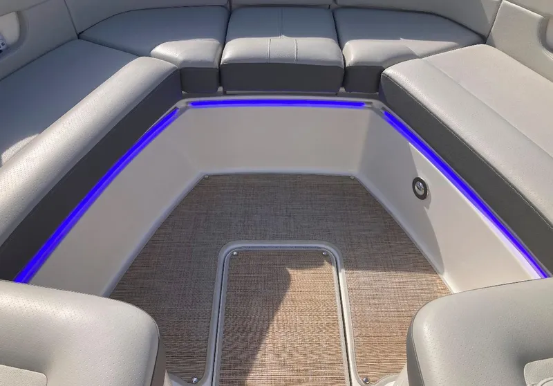 Slide: The Image of 2021 Sea Ray SLX 310 OB boat interior with gray seating and blue LED lighting. - 10