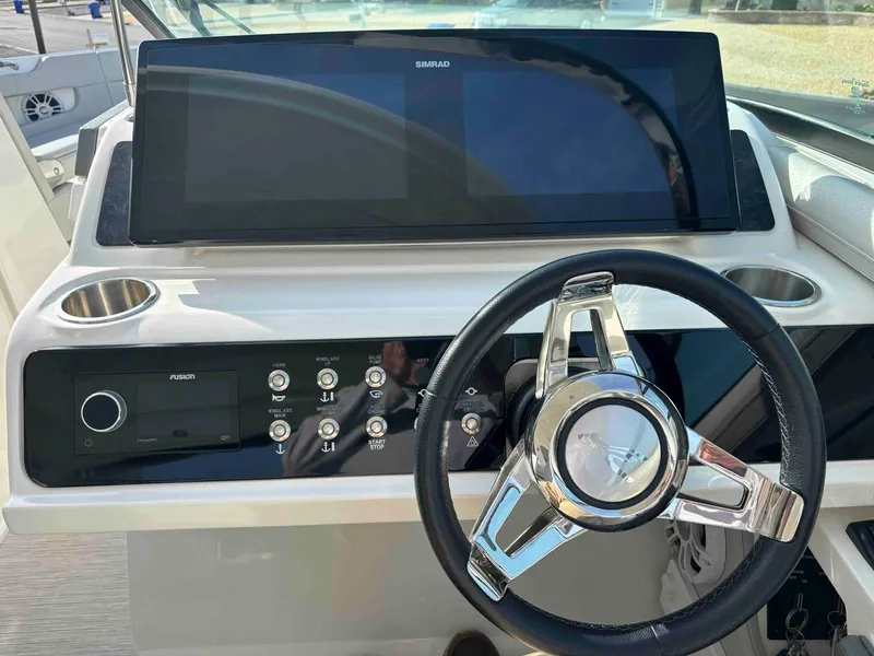 Slide: The Image of 2021 Sea Ray SLX 310 OB dashboard with steering wheel and control panel. - 11