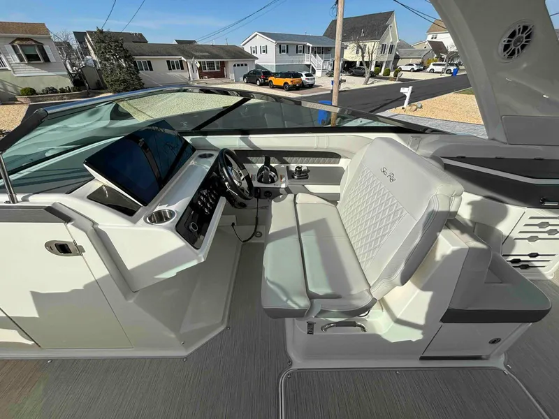 Slide: The Image of 2021 Sea Ray SLX 310 OB boat cockpit with modern controls and seating. - 13