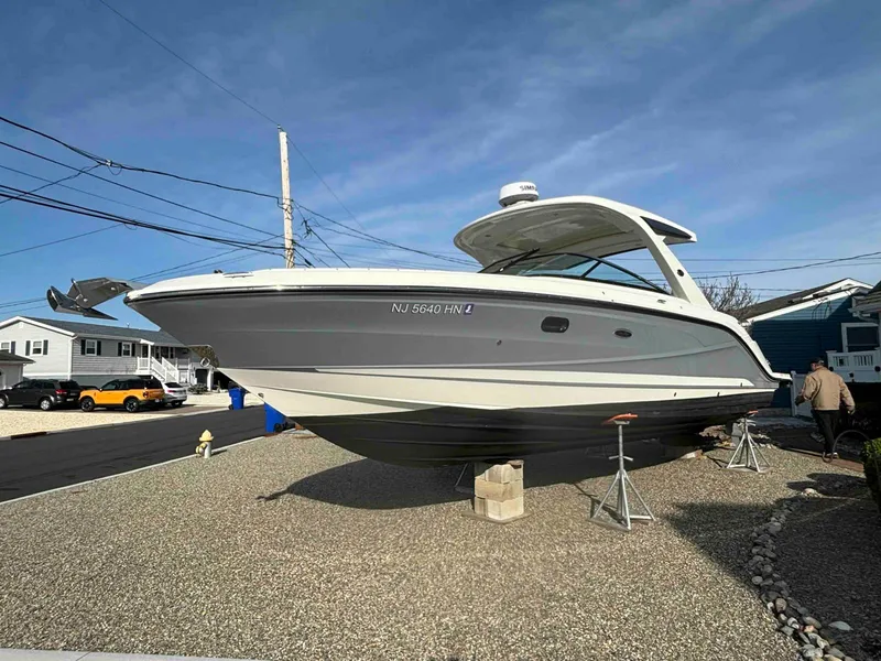 Slide: The Image of 2021 Sea Ray SLX 310 OB boat on display in a residential area. - 2