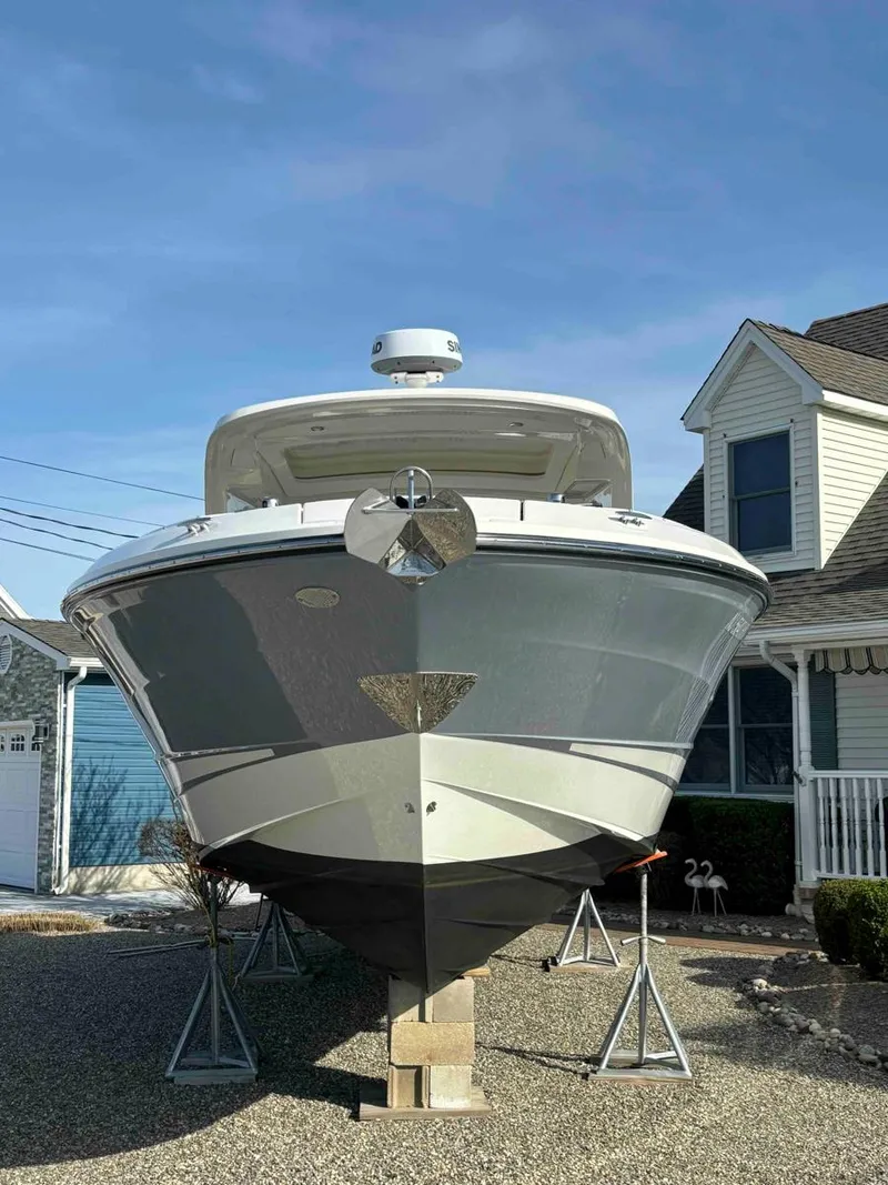 Slide: The Image of 2021 Sea Ray SLX 310 OB boat on stands in residential driveway. - 35
