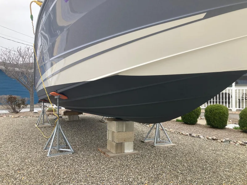 Slide: The Image of 2021 Sea Ray SLX 310 OB boat on stands, gravel surface, side view. - 36