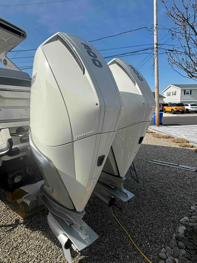 Slide: The Image of 2021 Sea Ray SLX 310 OB with dual outboard engines, parked on gravel. - 39