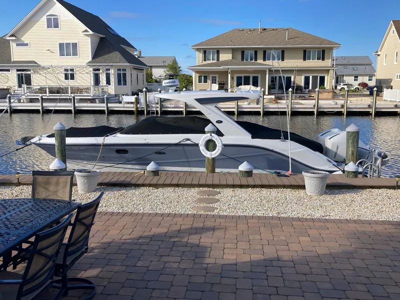 Slide: The Image of 2021 Sea Ray SLX 310 OB boat docked by waterfront homes. - 7