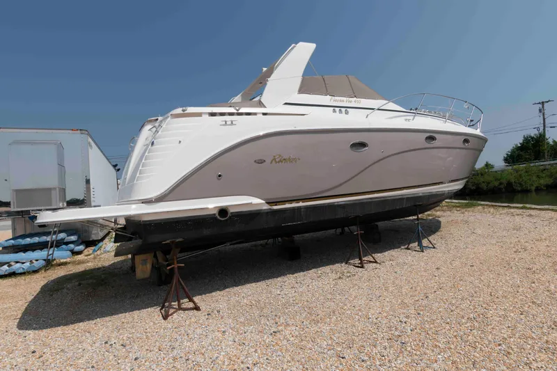 Slide: The Image of 2006 Rinker 410 Express Cruiser on dry dock, side view, clear sky background. - 1
