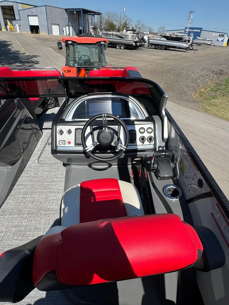 Slide: The Image of 2023 South Bay 25 Sport RS9 DC boat interior with red and gray seating, steering console. - 4