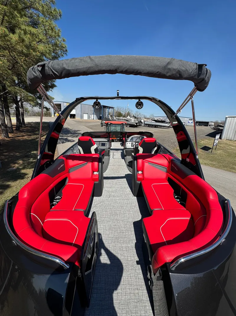 Slide: The Image of 2023 South Bay 25 Sport RS9 DC boat with red seating and canopy, docked outdoors. - 9