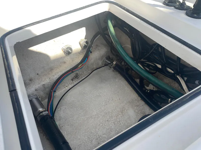 Slide: The Image of Open compartment of 2022 Catalyst 2550 CAT boat showing wiring and hoses. - 11