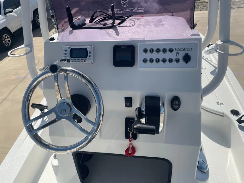 Slide: The Image of 2022 Catalyst 2550 CAT boat console with steering wheel and controls. - 19