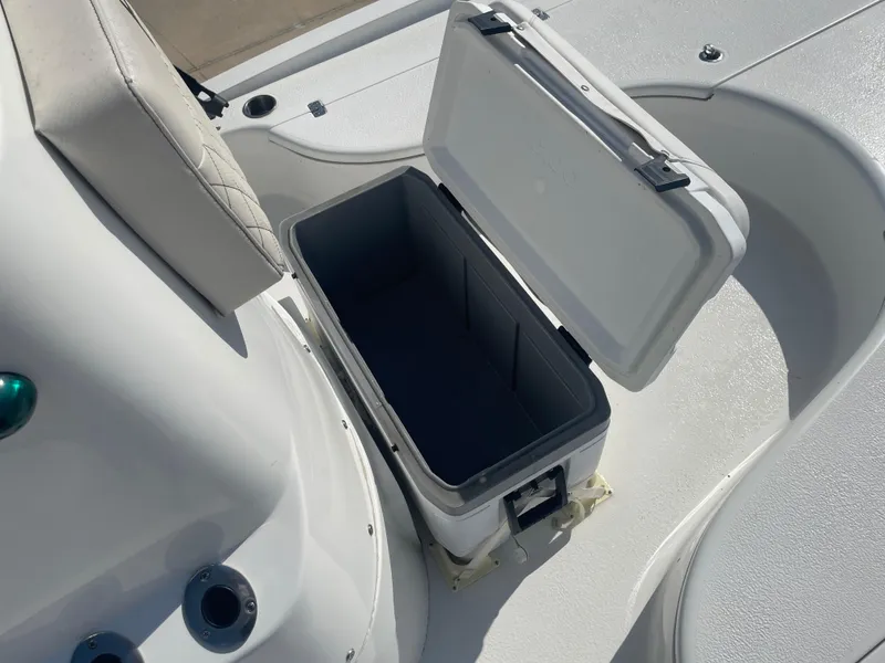 Slide: The Image of Open storage compartment on 2022 Catalyst 2550 CAT boat, featuring a white cushioned seat. - 21