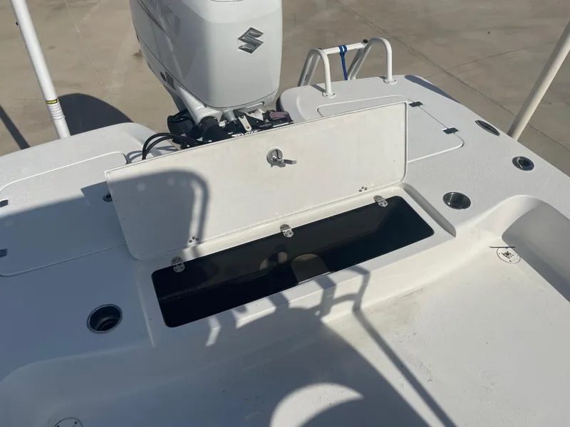 Slide: The Image of 2022 Catalyst 2550 CAT boat deck with open storage compartment and Suzuki outboard motor. - 9