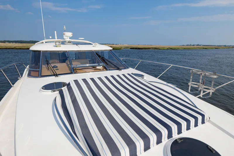 Slide: The Image of 2000 Neptunus 54 Express yacht with striped sunpad on deck, cruising on calm waters. - 10