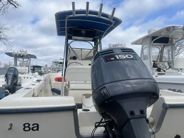 Slide: The Image of 2002 Sea Hunt 202 TRITON boat with V6 150 engine, docked under cloudy sky. - 4