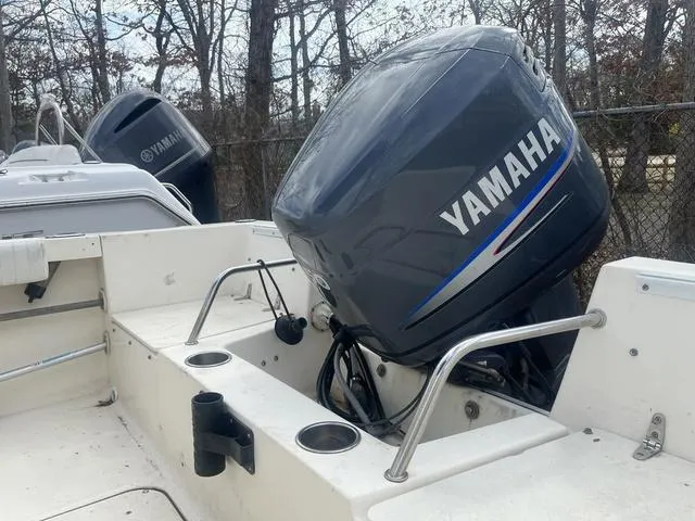 Slide: The Image of 2002 Sea Hunt 202 TRITON boat with Yamaha outboard motor, docked near trees. - 5