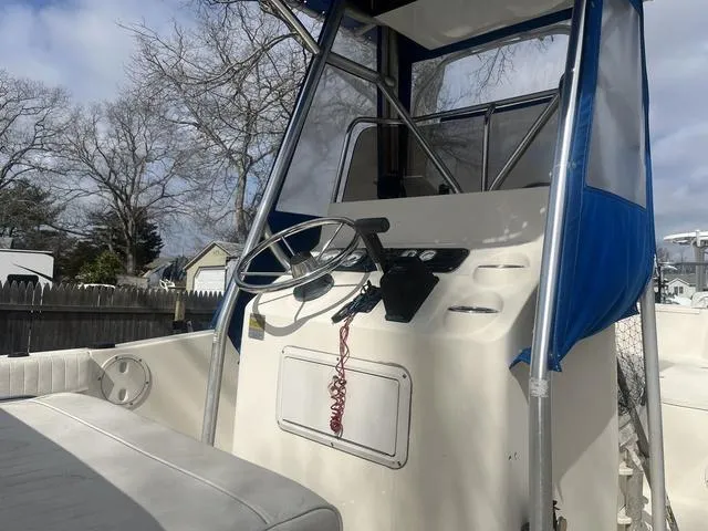 Slide: The Image of 2002 Sea Hunt 202 TRITON boat console with steering wheel and blue canopy. - 7
