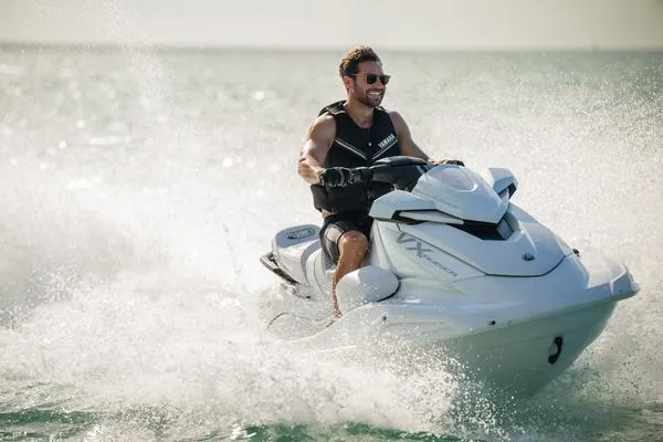 Slide: The Image of 2025 Yamaha Waverunner VX Cruiser with Audio, rider enjoying waves, sunny day. - 11