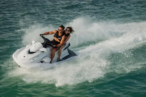 Slide: The Image of 2025 Yamaha VX Cruiser jet ski with audio, two riders enjoying a fast ride on the water. - 12