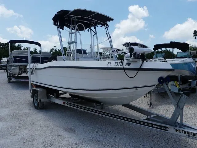 Slide: The Image of 2009 Angler 180 CC boat on trailer, parked outdoors under a clear sky. - 1