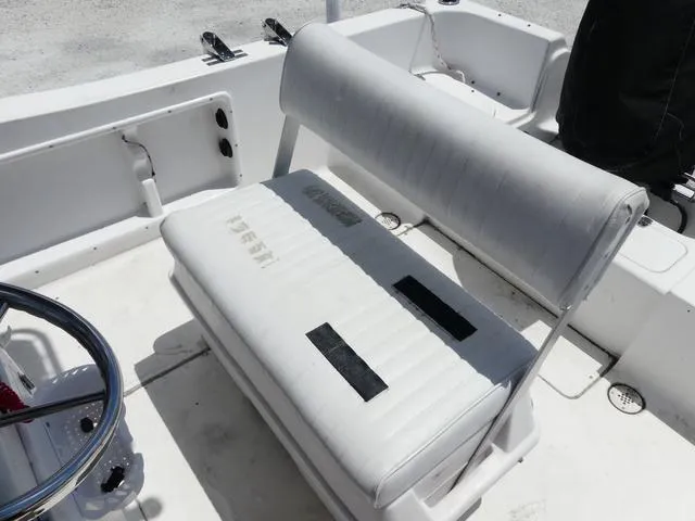 Slide: The Image of 2009 Angler 180 CC boat interior with white cushioned seating and steering wheel. - 9