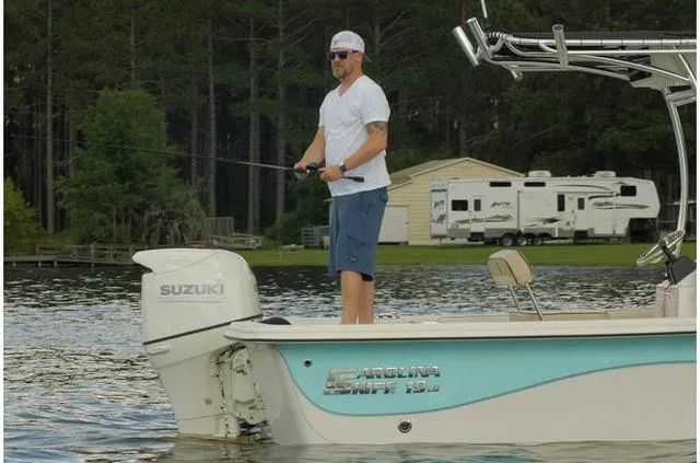 Slide: The Image of Man fishing on a 2020 Carolina Skiff 19LS boat with Suzuki engine. - 1