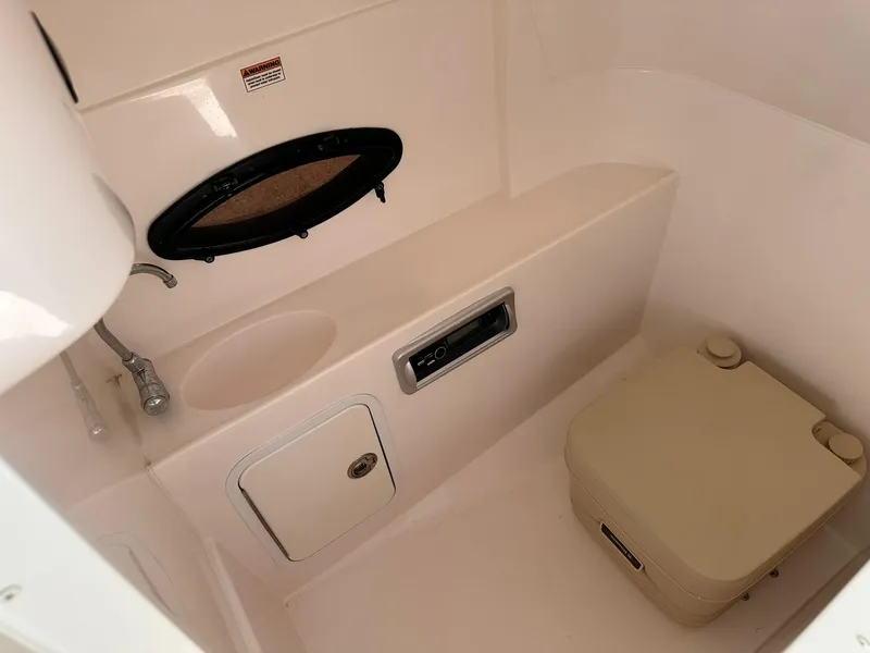 Slide: The Image of 2012 Hurricane SD2400 OB boat interior with sink, storage, and portable toilet. - 22