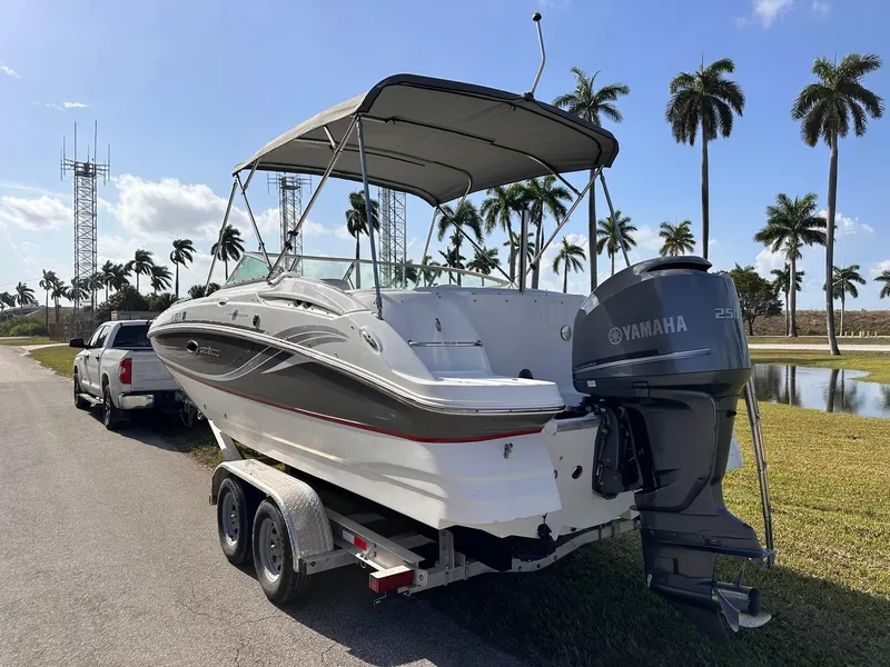 Slide: The Image of 2012 Hurricane SD2400 OB boat on trailer with Yamaha engine, parked near palm trees. - 5