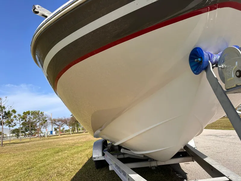 Slide: The Image of 2012 Hurricane SD2400 OB boat on trailer, parked on grass under clear blue sky. - 9