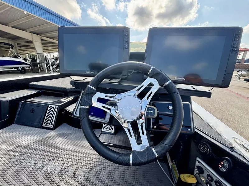 Slide: The Image of 2023 Caymas CX 21 boat dashboard with dual Garmin displays and steering wheel. - 3