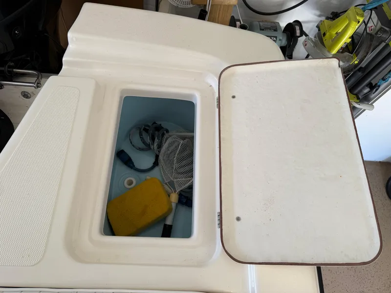 Slide: The Image of Open storage compartment on a 2014 Bulls Bay 1700 boat with various items inside. - 15