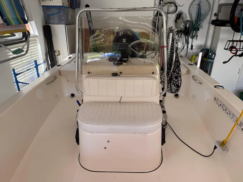 Slide: The Image of 2014 Bulls Bay 1700 boat interior with seating and steering console in a garage setting. - 27