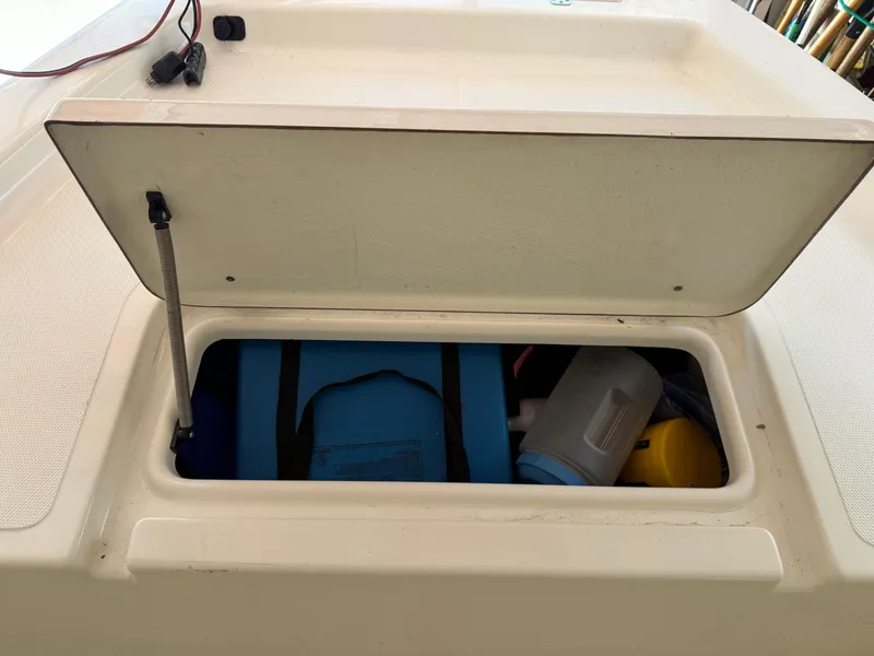 Slide: The Image of Open storage compartment on a 2014 Bulls Bay 1700 boat, containing various items. - 31