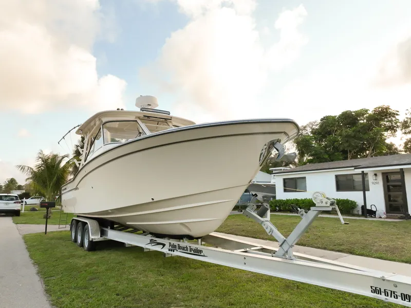 Slide: The Image of 2019 Grady-White Freedom 325 boat cruising on a sunny day near a city skyline. - 1
