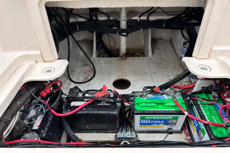 Slide: The Image of 2019 Grady-White Freedom 325 boat battery compartment with multiple batteries and wiring. - 43