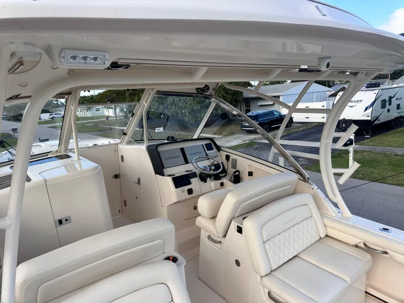 Slide: The Image of 2019 Grady-White Freedom 325 boat cruising on open water, showcasing sleek design and powerful engines. - 9