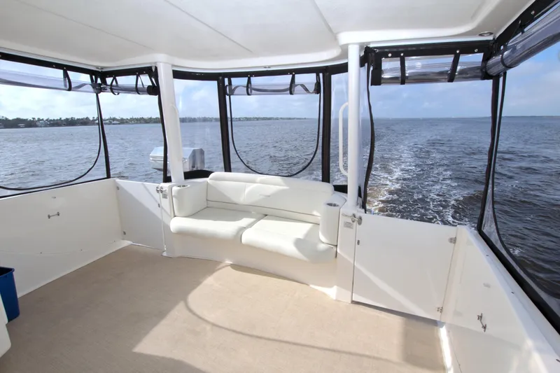 Slide: The Image of 2006 Silverton 39 Motor Yacht interior with white seating, overlooking calm waters. - 12