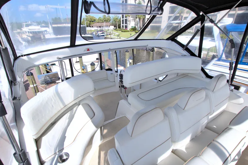 Slide: The Image of 2006 Silverton 39 Motor Yacht interior with white seating and marina view. - 35